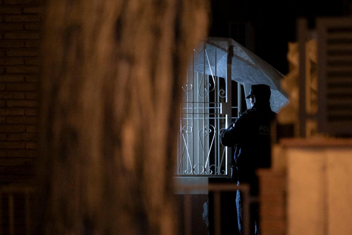 Un agente de los Mossos d'Esquadra acude al piso de Horta-Guinardó en la que han aparecido los tres cuerpos.