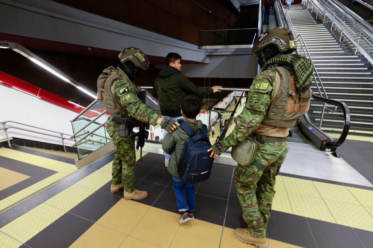 Dos militares buscan objetos ilegales en uan parada del metro de Quito.