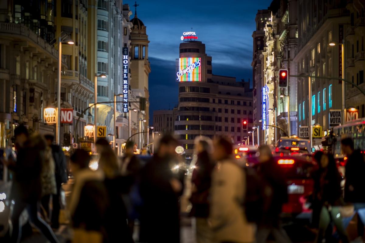 Un grupo de viandantes cruza la Gran Vía de Madrid.