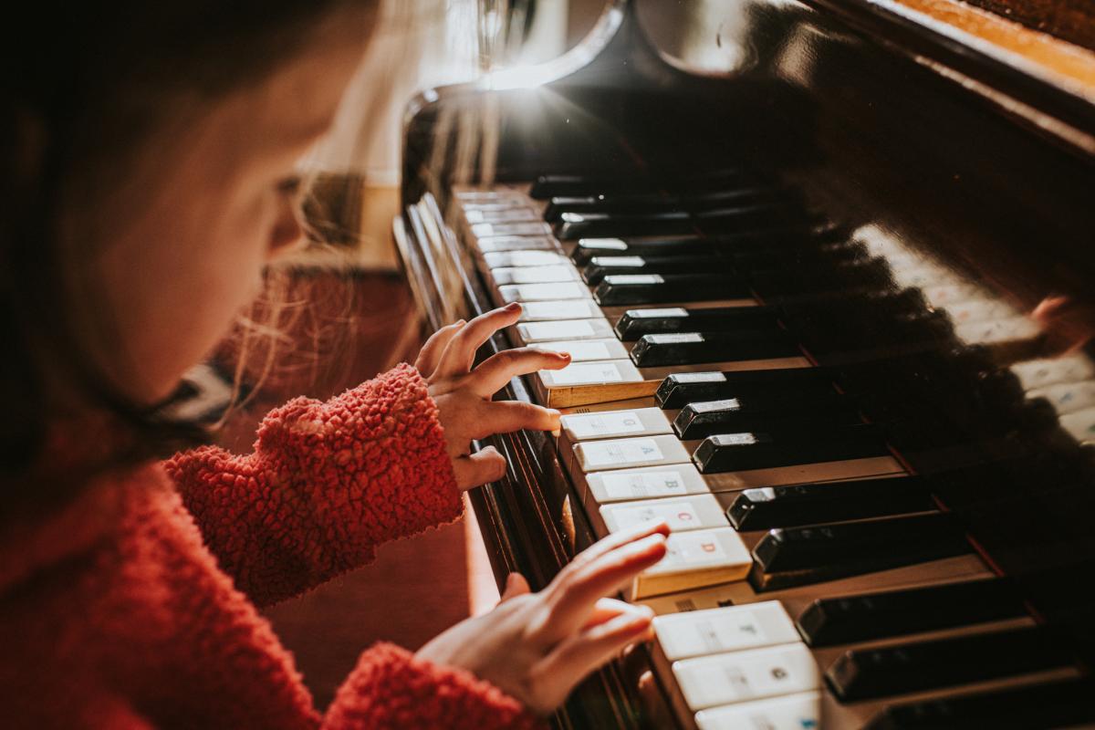Imagen de archivo de una niña tocando el piano.