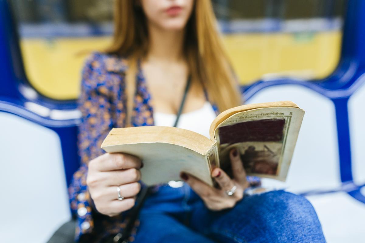 Una mujer leyendo en el metro.