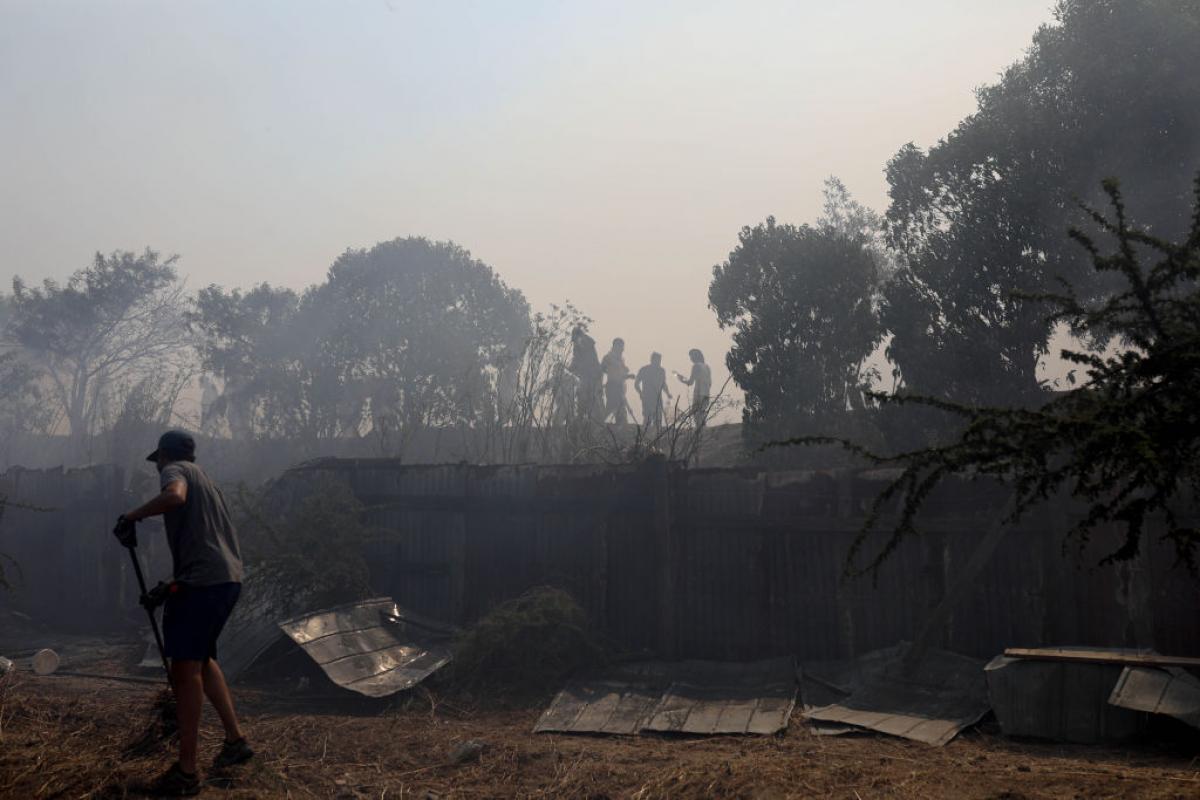 Un hombre limpia una zona quemada en Vina del Mar, en Chile.