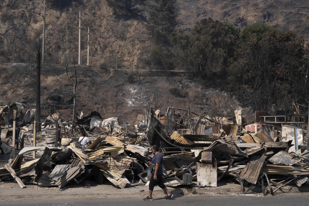 Un vecino pasa por delante de los escombros de varias casas en Viña del Mar.