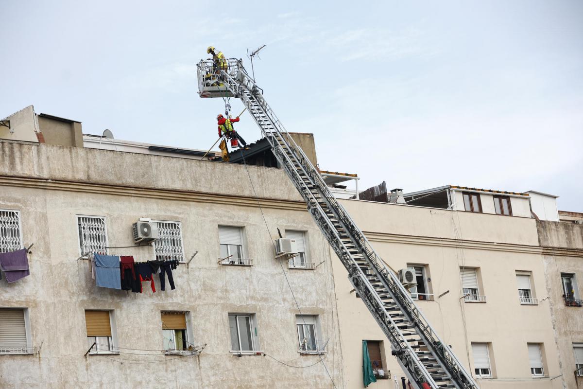 Los bomberos inspeccionan el interior de un edificio de cinco pisos, el bajo y otros cuatro, que se ha derrumbado en la calle Canigó de Badalona (Barcelona), al haber cedido el forjado de la construcción.