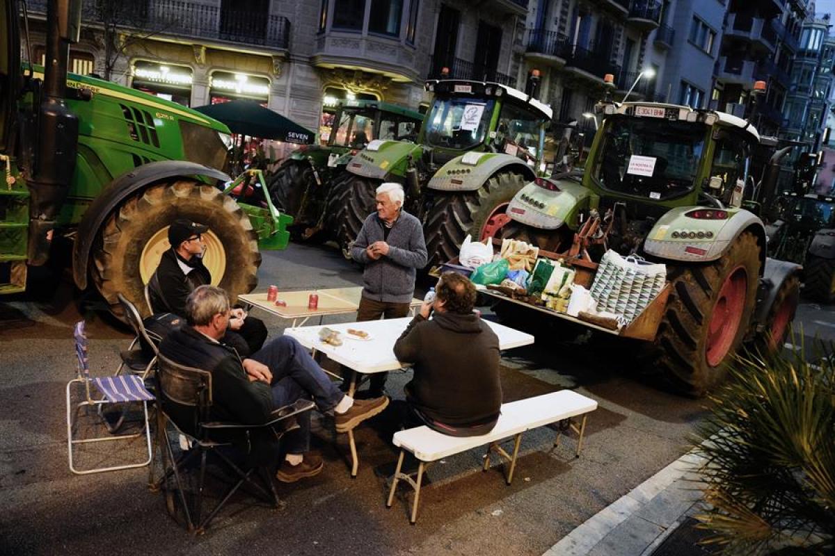 Varios de los manifestantes, acampados junto a sus tractores en pleno centro de Barcelona