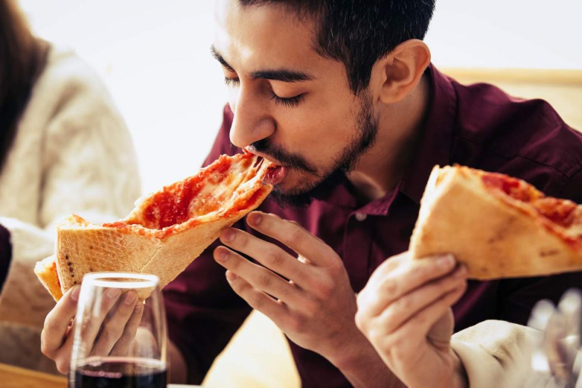 Hombre disfrutando de una pizza