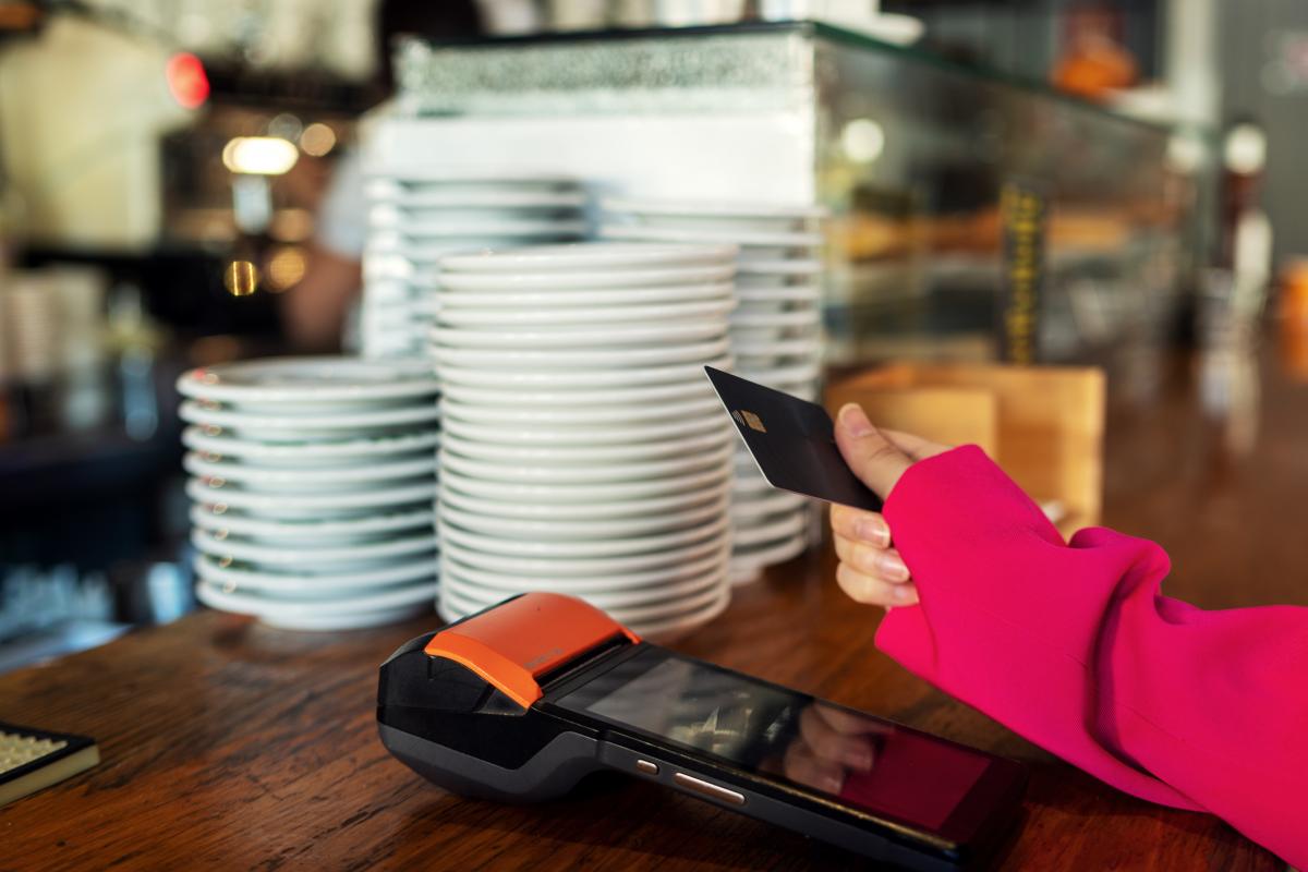 Una persona pagando en un establecimiento hostelero.