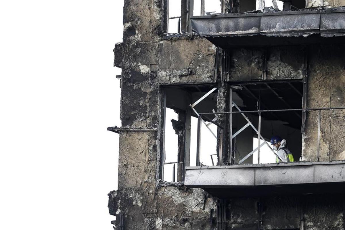 Un agente de la Policía Científica inspecciona una vivienda del edificio incendiado en el barrio de Campanar de Valencia