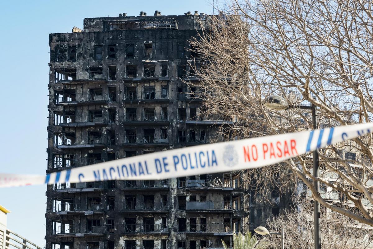 Una cinta policial impide el paso hacia los edificios afectados por un incendio ayer jueves en València, en el que de momento se contabilizan cuatro víctimas mortales, a falta de poder acceder al interior de la estructura, mientras que las personas no localizadas se sitúan en estos momentos en 14, aunque esta cifra puede ir variando conforme prosigan las investigaciones.