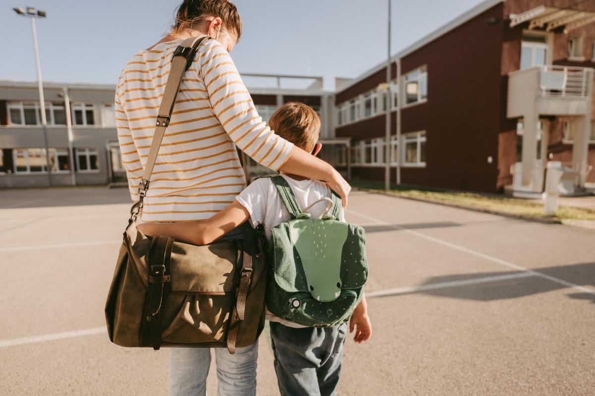 Una madre con su hijo frente al colegio.