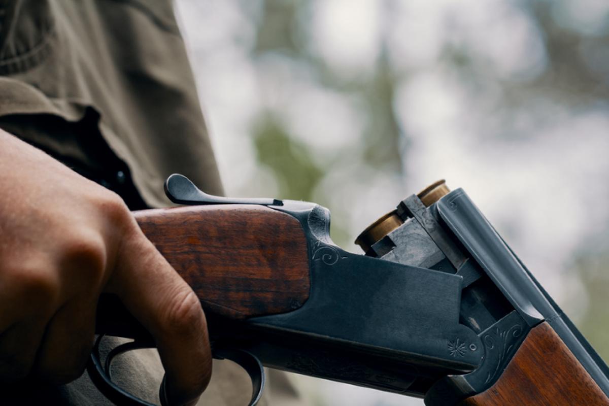 Imagen de archivo de un cazador cargando una escopeta.