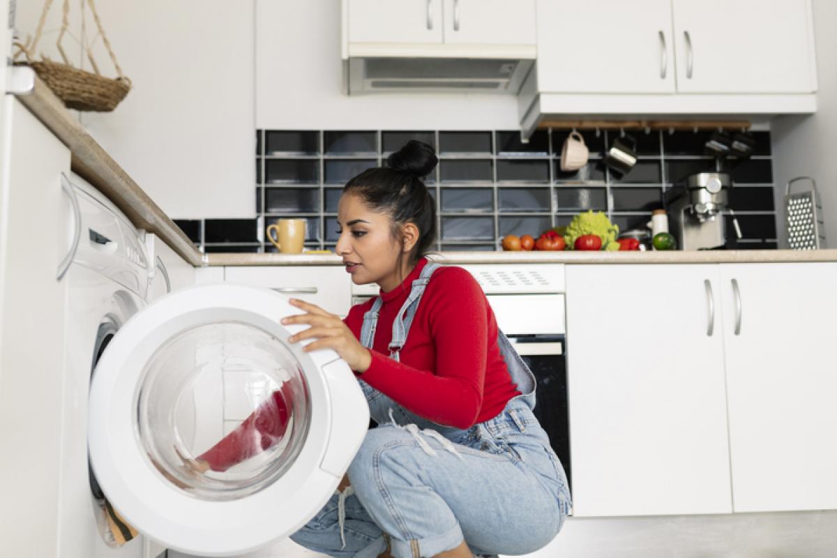 Imagen de archivo de una mujer poniendo una lavadora.