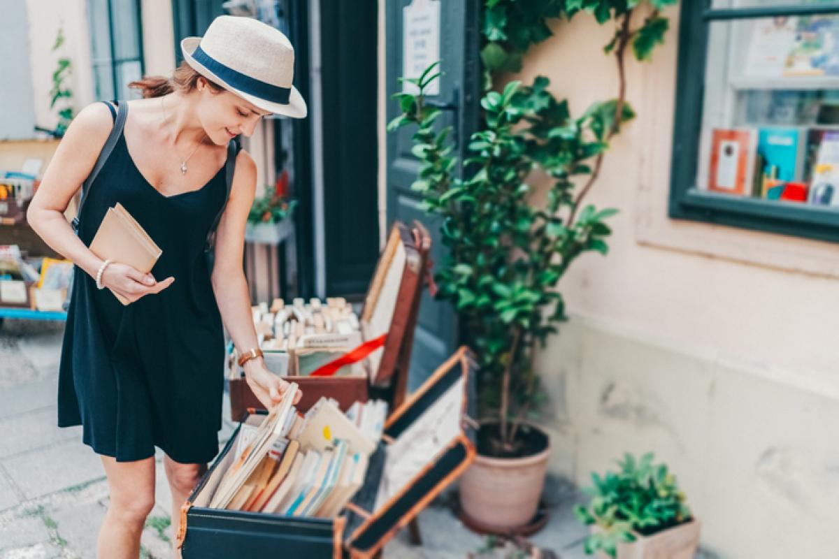 Imagen de una mujer ojeando libros de segunda mano.
