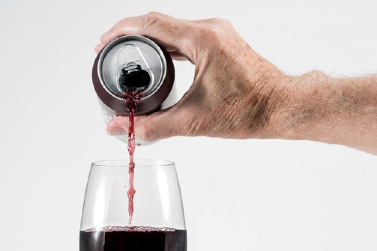 Imagen de archivo de una persona vertiendo un vino de lata en una copa.