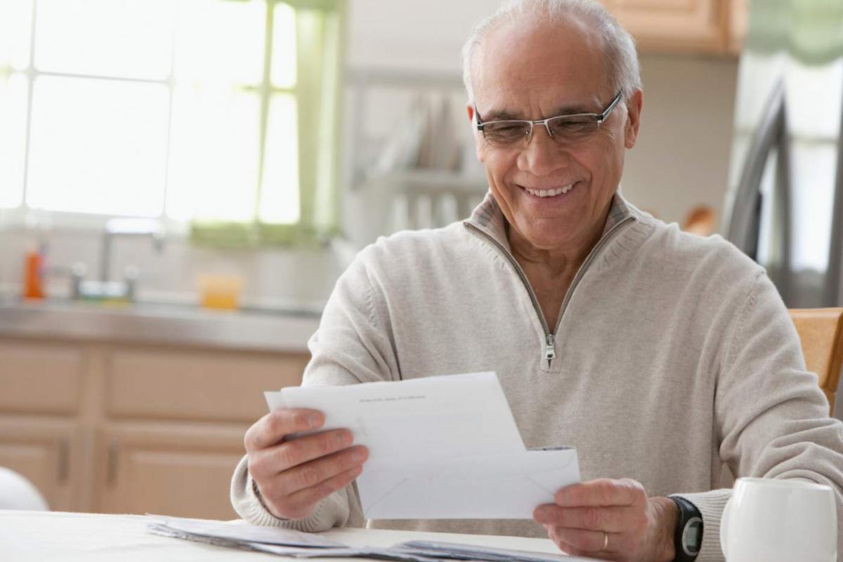 Hombre leyendo una carta en la cocina