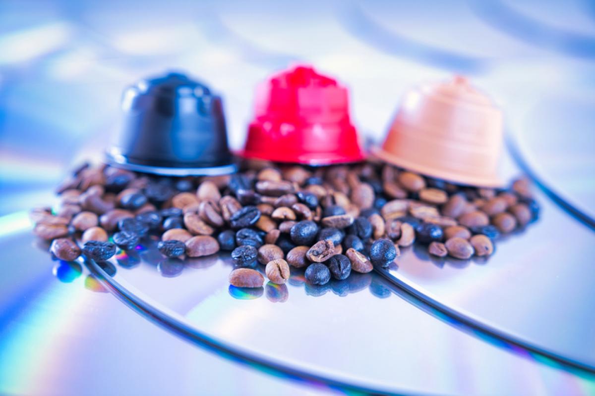 Imagen de tres cápsulas con granos de café al lado.