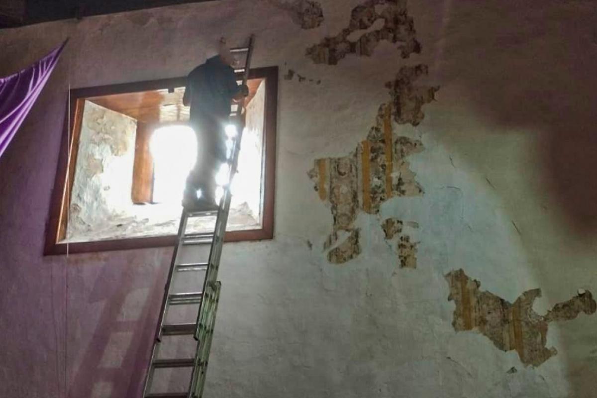 Un operario pinta sobre los frescos de la parroquia de San Antonio de Padua, en El Tanque