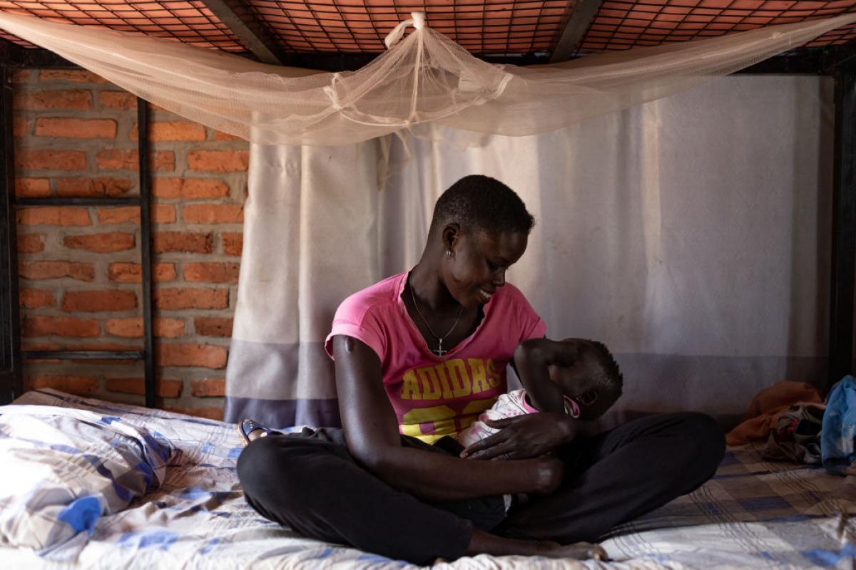 Una refugiada sudanesa sostiene a su hijo en brazos en un albergue de Ruanda.