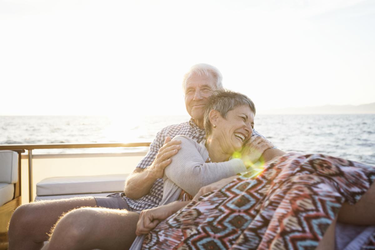 Dos personas mayores disfrutando de un viaje en el mar.
