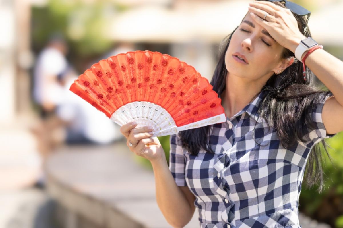 Una mujer abanicándose por el calor.