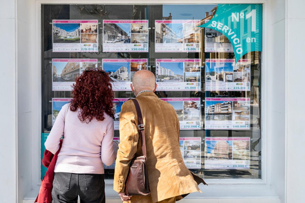 Imagen de archivo de varias personas observando los anuncios en el escaparate de una inmobiliaria, en Alicante (Comunidad Valenciana).