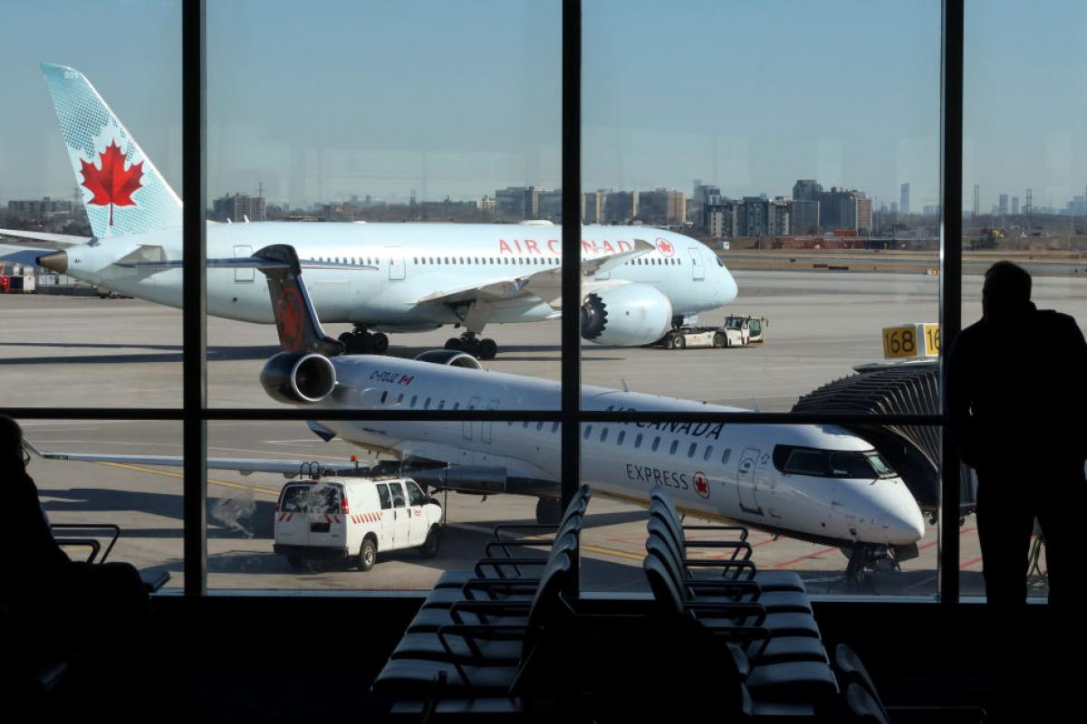 Una persona observa un avión de Air Canadá en el Aeropuerto Internacional Pearson de Toronto.