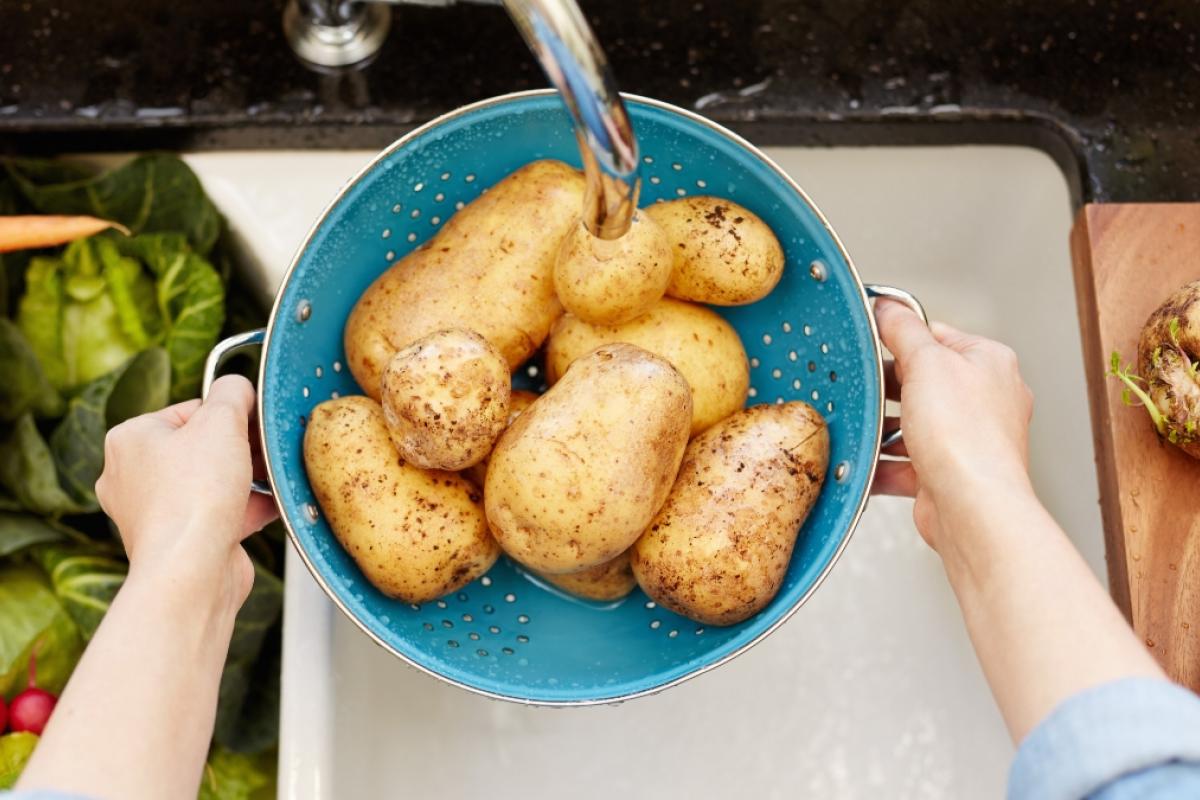 Mujer lavando patatas