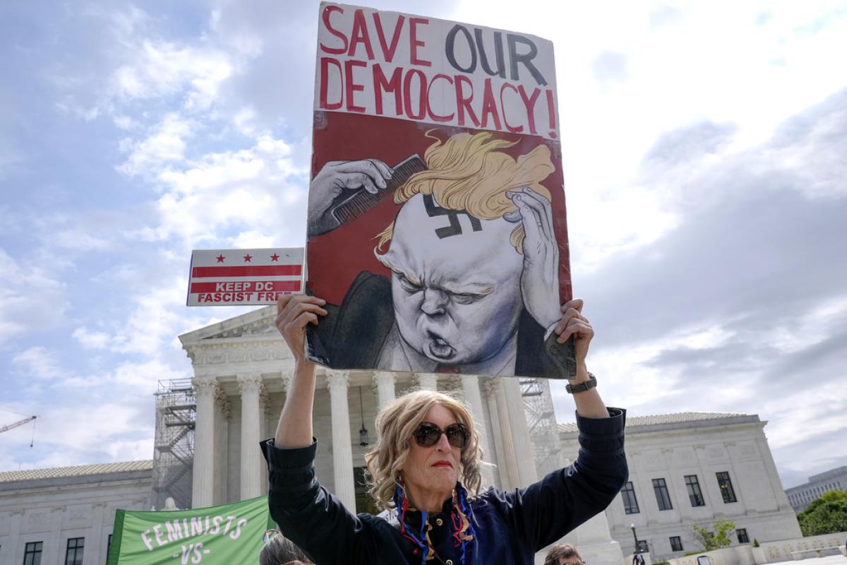 Una mujer protesta ante el Tribunal Supremo de los EEUU con un cartel contra Donald Trump.