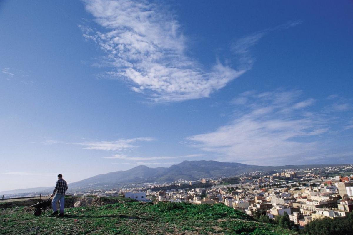 Un hombre con carretilla observa Melilla desde el Monte Gurugú, en Marruecos.