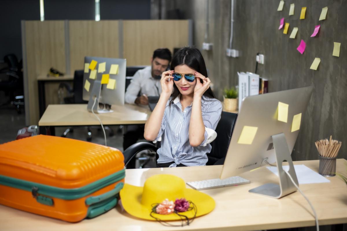 Una mujer con su maleta preparada en una mesa de oficina.