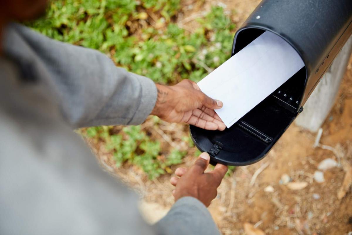 Hombre sacando una carta del buzon