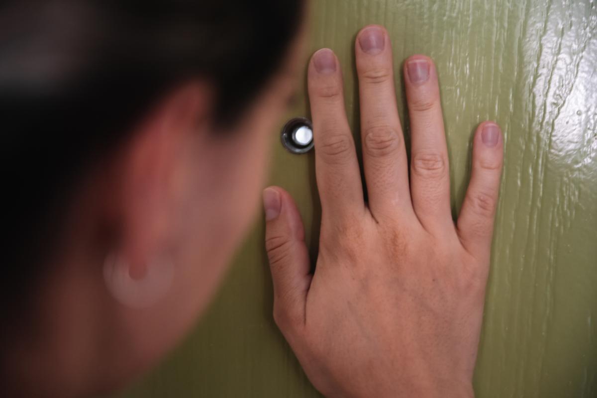 Mujer mirando por la mirilla.