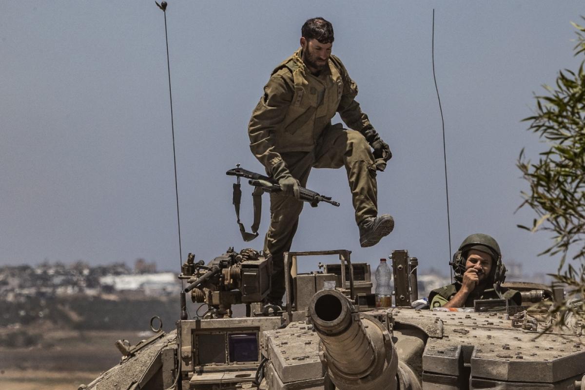 Soldado israelí controlando un tanque mientras continúa la movilización militar del ejército israelí cerca de la frontera de Gaza