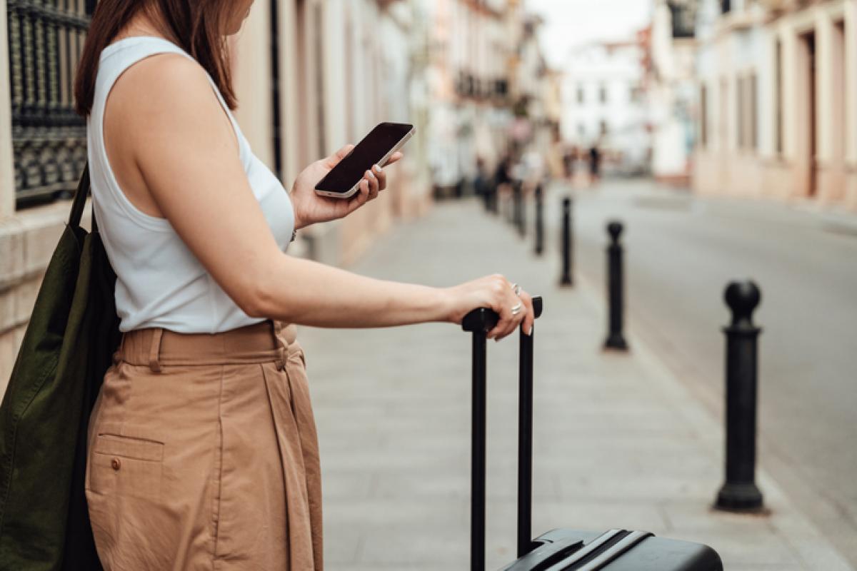 Imagen de archivo de una turista pidiendo un VTC con su 'smartphone'.