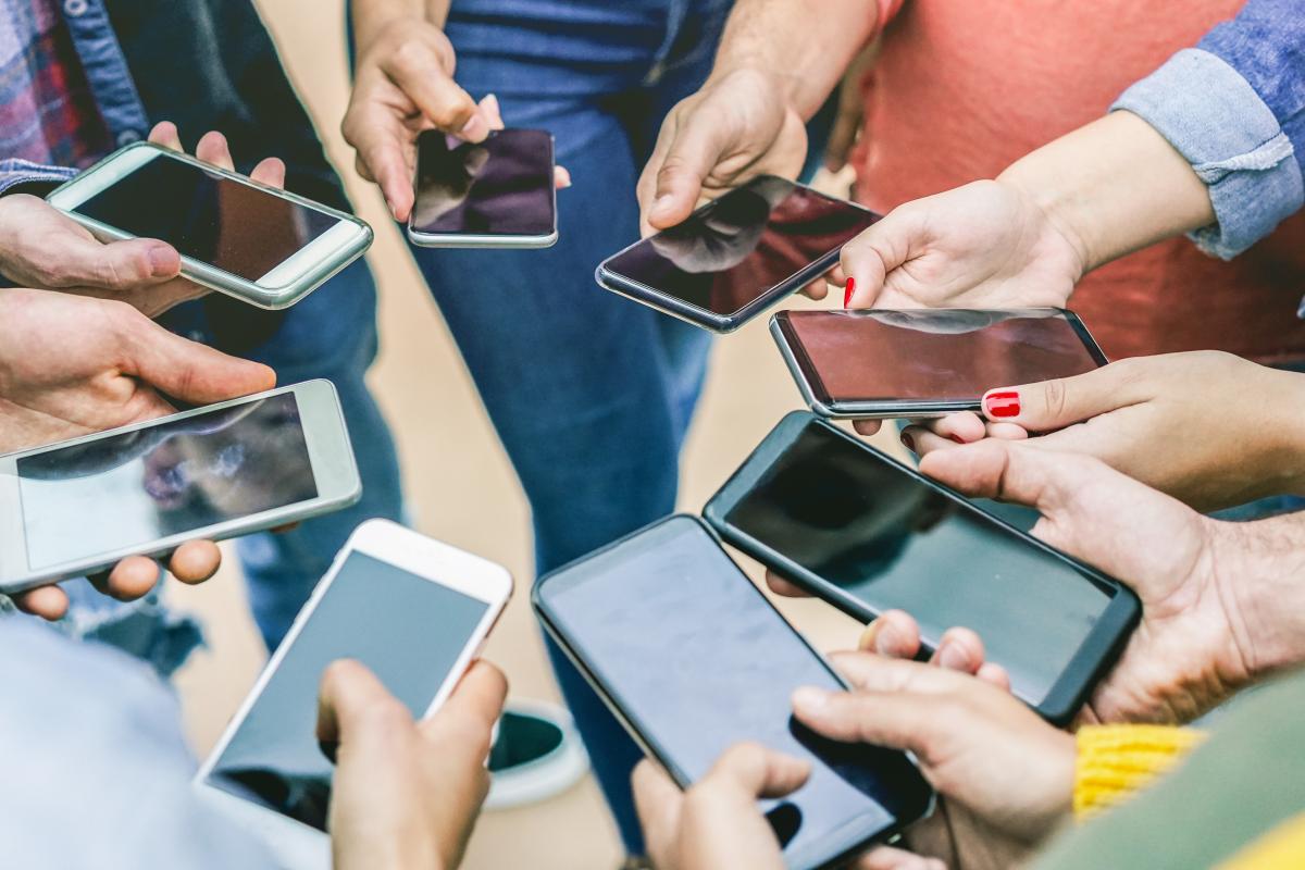 Imagen de archivo de un grupo de adolescentes con sus teléfonos móviles.