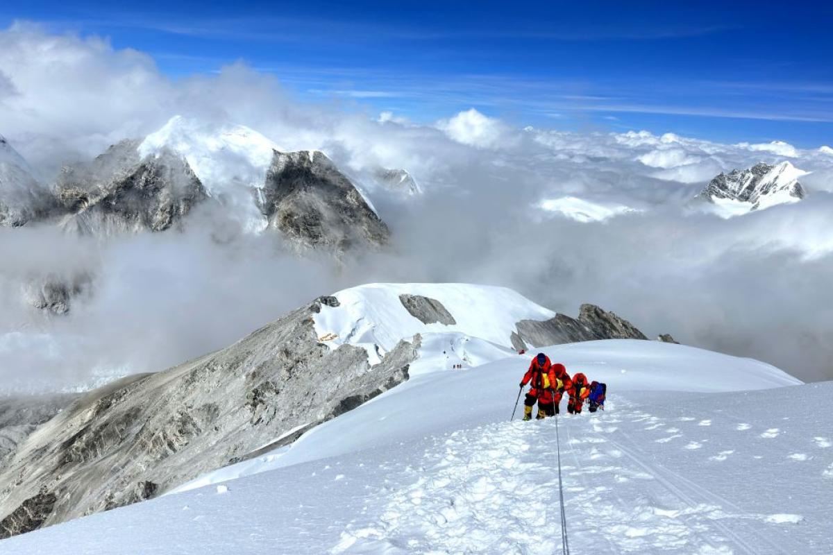 Un grupo de alpinistas asciende hacia la cumbre del Everest.