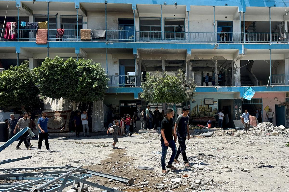 Palestinos comprueban los daños en una escuela de la UNRWA en Al Nuseirat -funcionan como campos de refugiados tras la respuesta israelí a los atentados del 7 de octubre-, tras el bombardeo de Israel, en el centro de la Franja de Gaza.