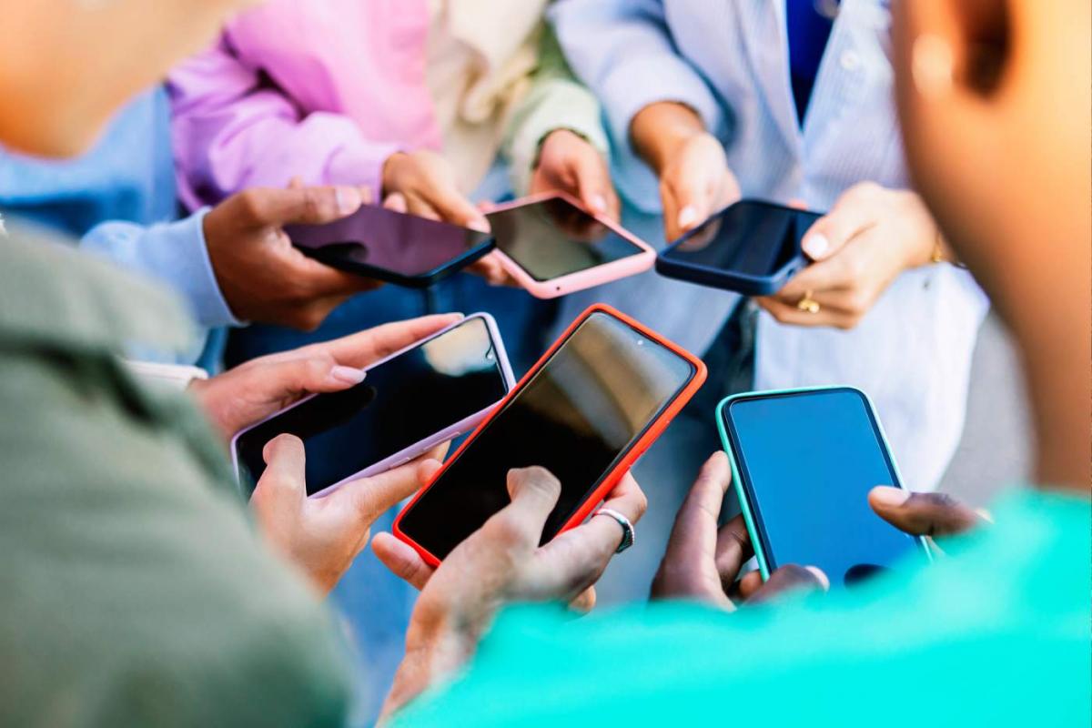 Niños reunidos usando el móvil