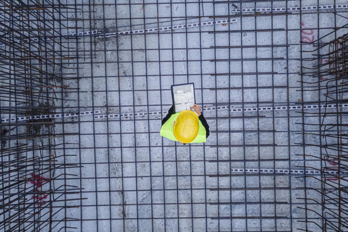 Imagen de archivo de un operario en una obra, sobre los cimientos, visto desde arriba.