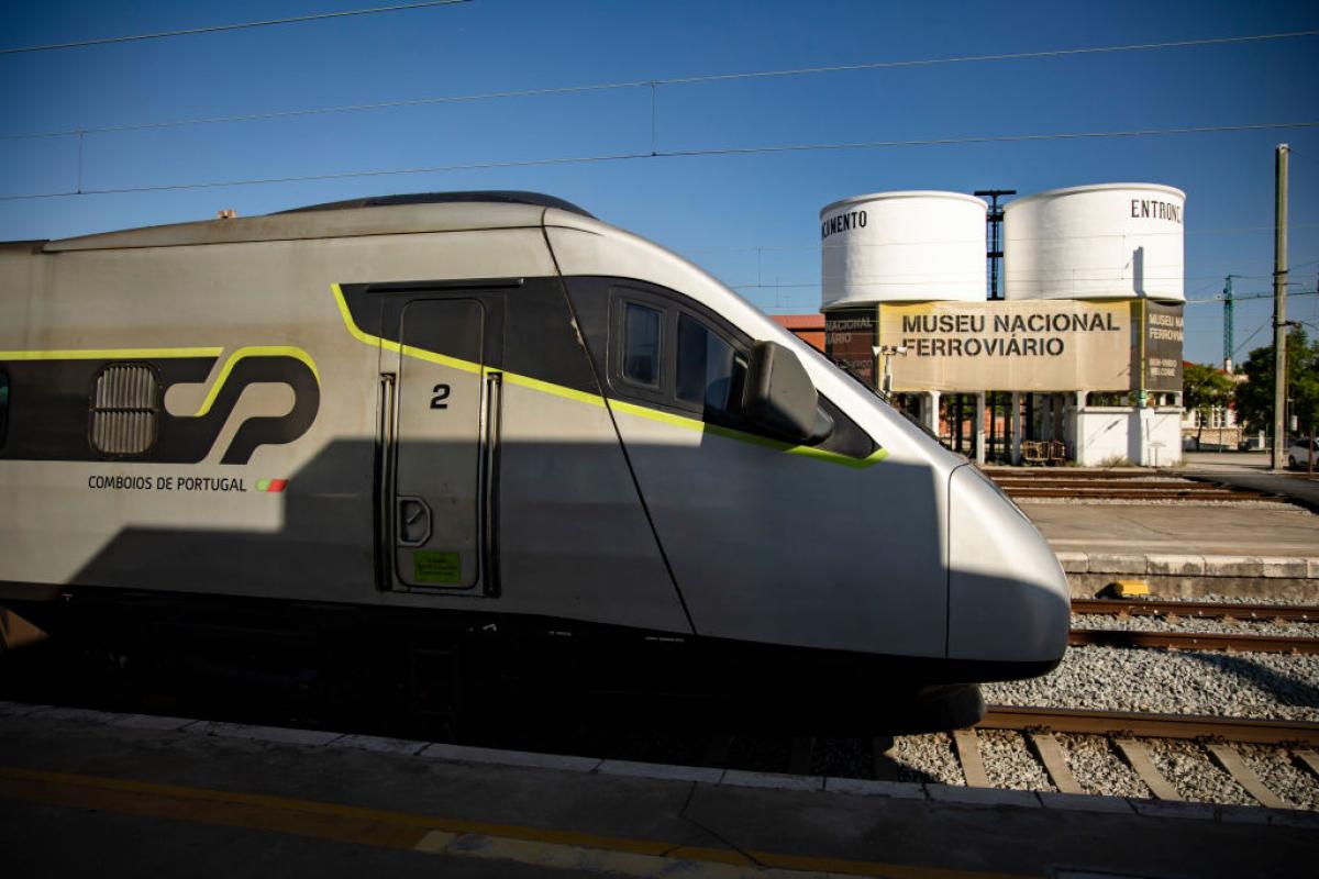 Un tren de alta velocidad de la empresa Comboios de Portugal entra en una estación.