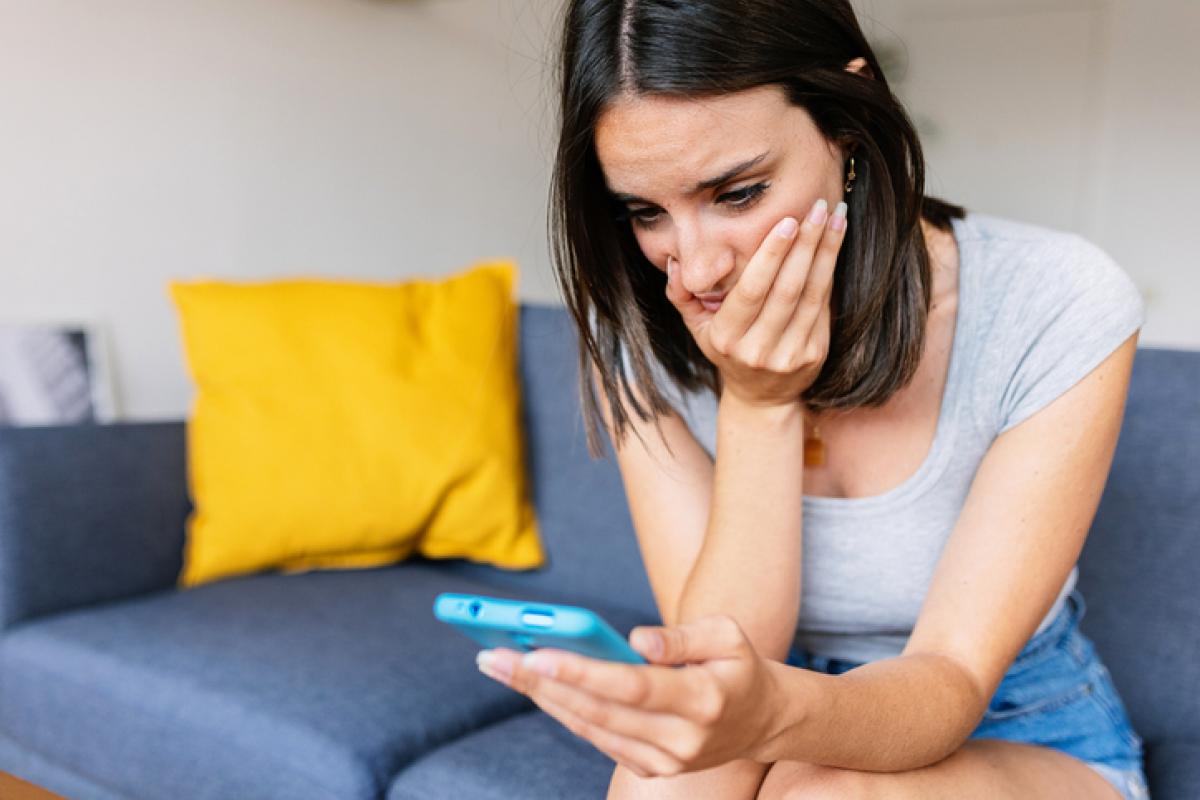 Imagen de una persona observando algo con preocupación en su teléfono móvil.