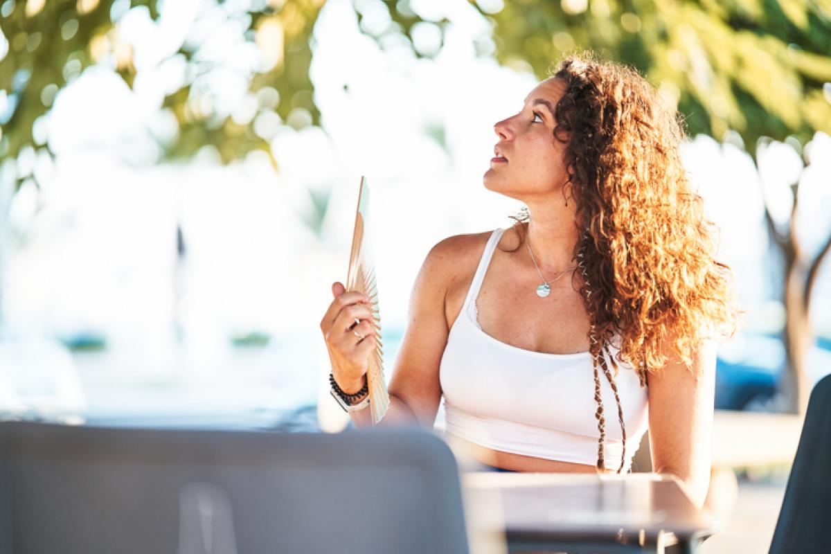 Imagen de archivo de una mujer con un abanico, en un día caluroso.