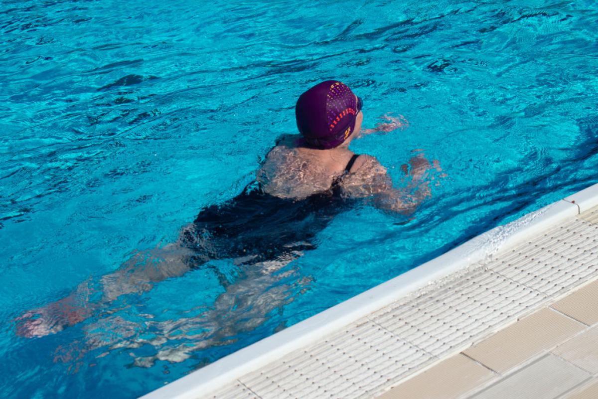 Una mujer, nadando en una piscina