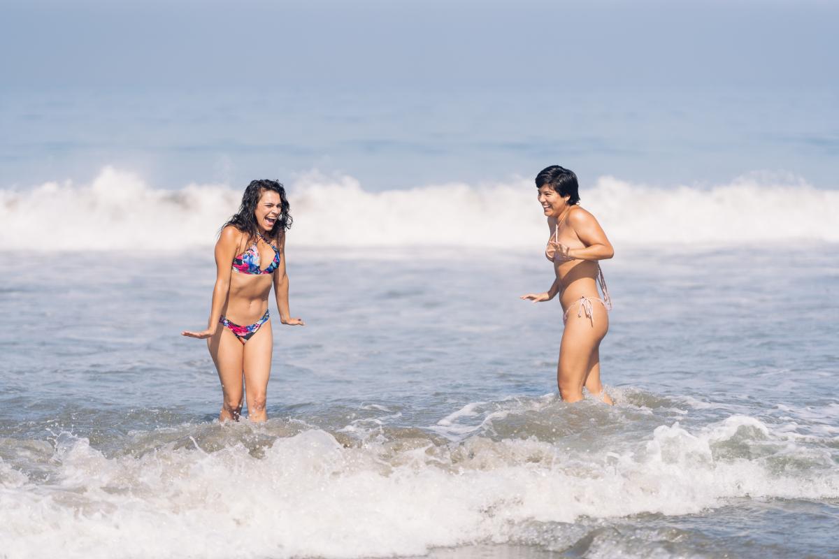 Dos mujeres entrando en el agua fría del mar.