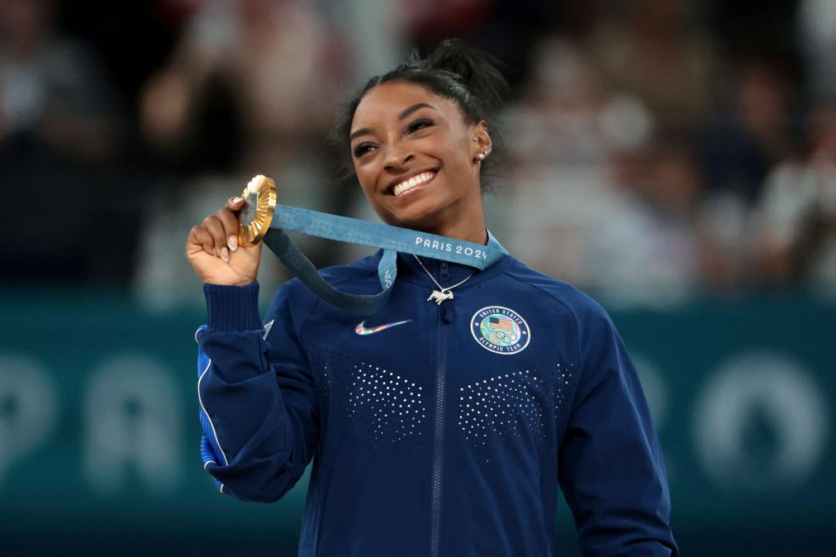 Simon Biles feliz con su medalla de oro en el concurso completo femenino de gimnasia artística.