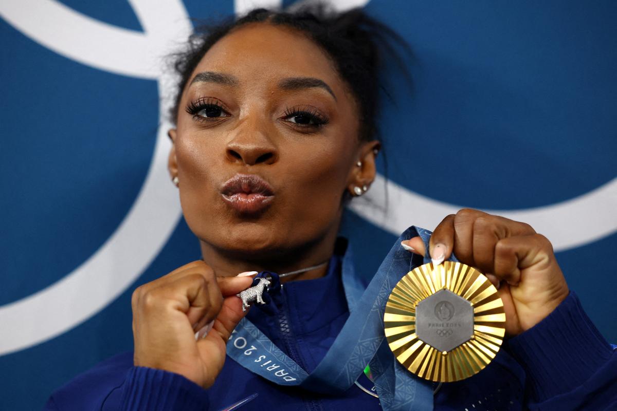 Simone Biles muestra su medalla de oro en el concurso  completo de gimnasia en París 2024