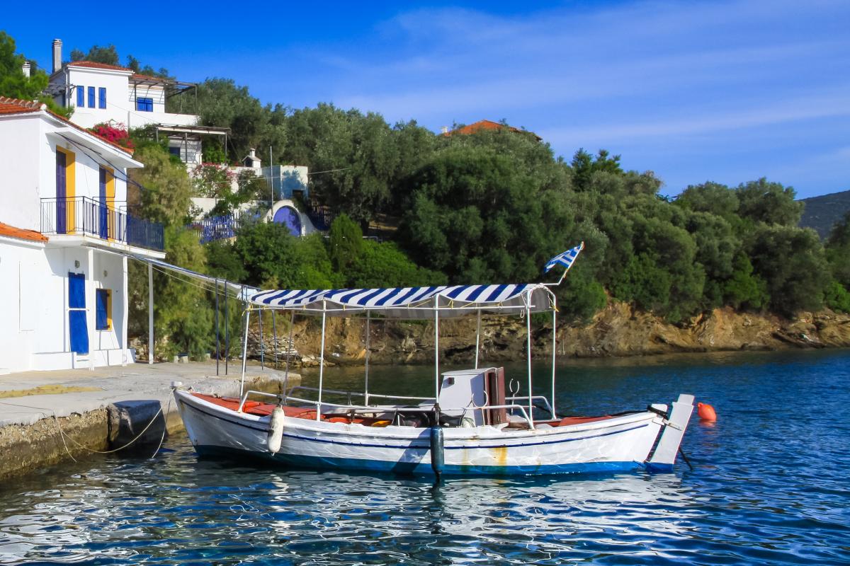 Kaiki blanco y azul amarrado en la isla Paleo Trikeri.