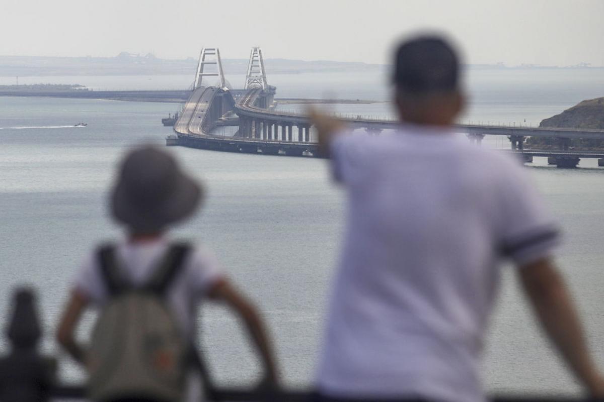 Dos personas observan desde lejos el puente de Crimea.