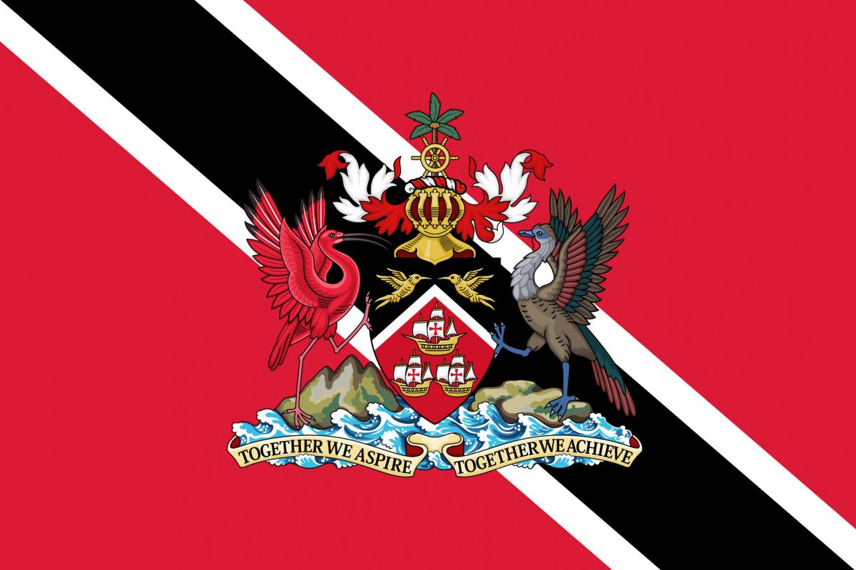 La bandera oficial de la República de Trinidad y Tobago, en la que puede verse el escudo de armas con las tres carabelas de la expedición de Colón.