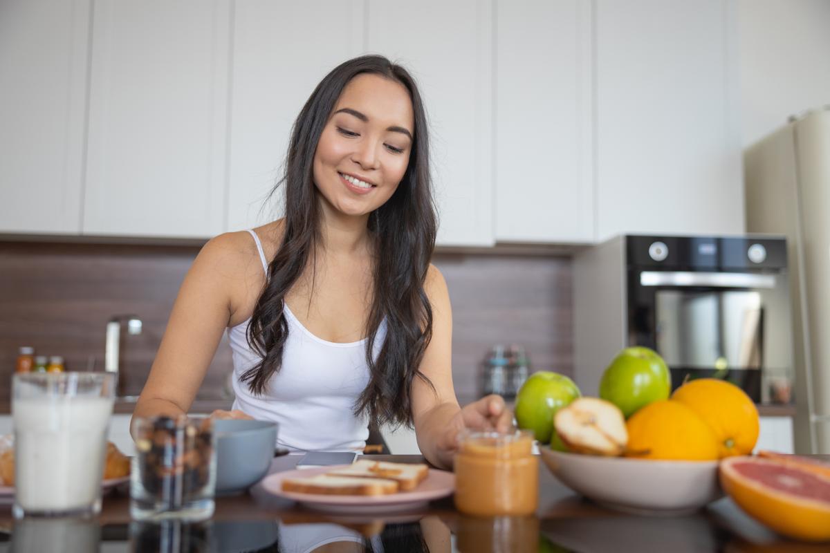 Imagen de archivo de una joven desayunando en la cocina.